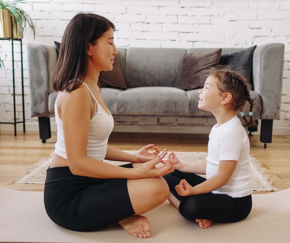 Una mujer y su hija practican juntas la meditación de atención plena.