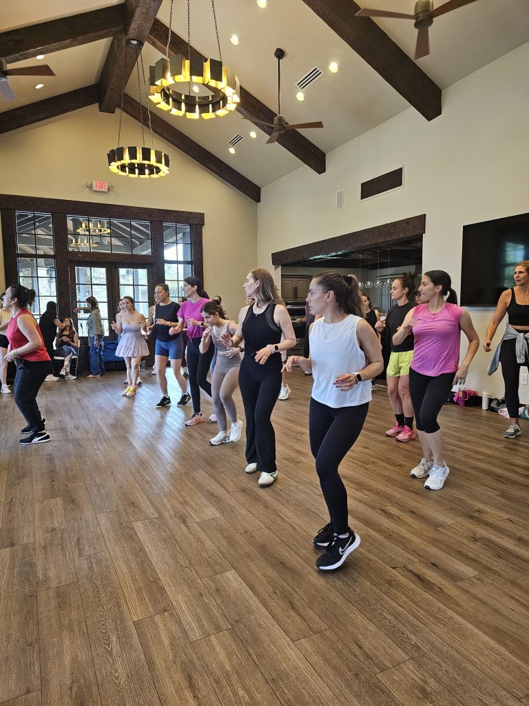 Un grupo de mujeres con ropa deportiva toma una clase de baile latino para recaudar fondos para la organización sin fines de lucro Aldea Austin.