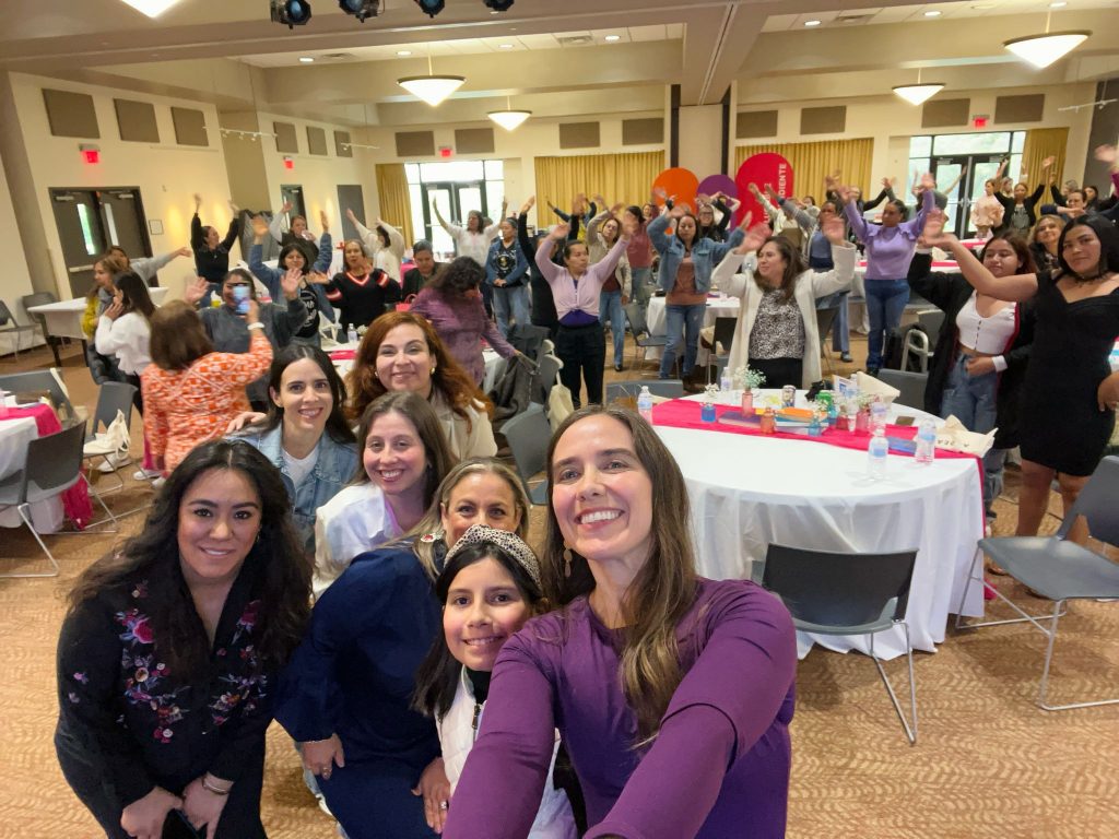 Un grupo de mujeres en un evento para recaudar fondos se toman una selfie para la cámara.