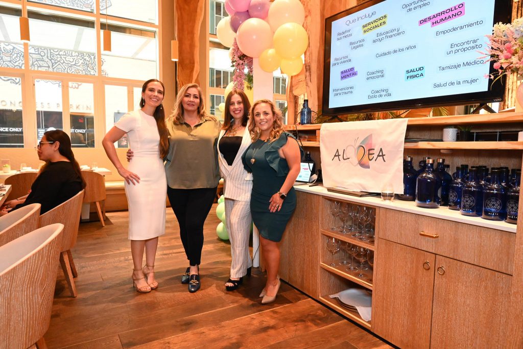 Four formally-dressed people at a fundraising event at a restaurant