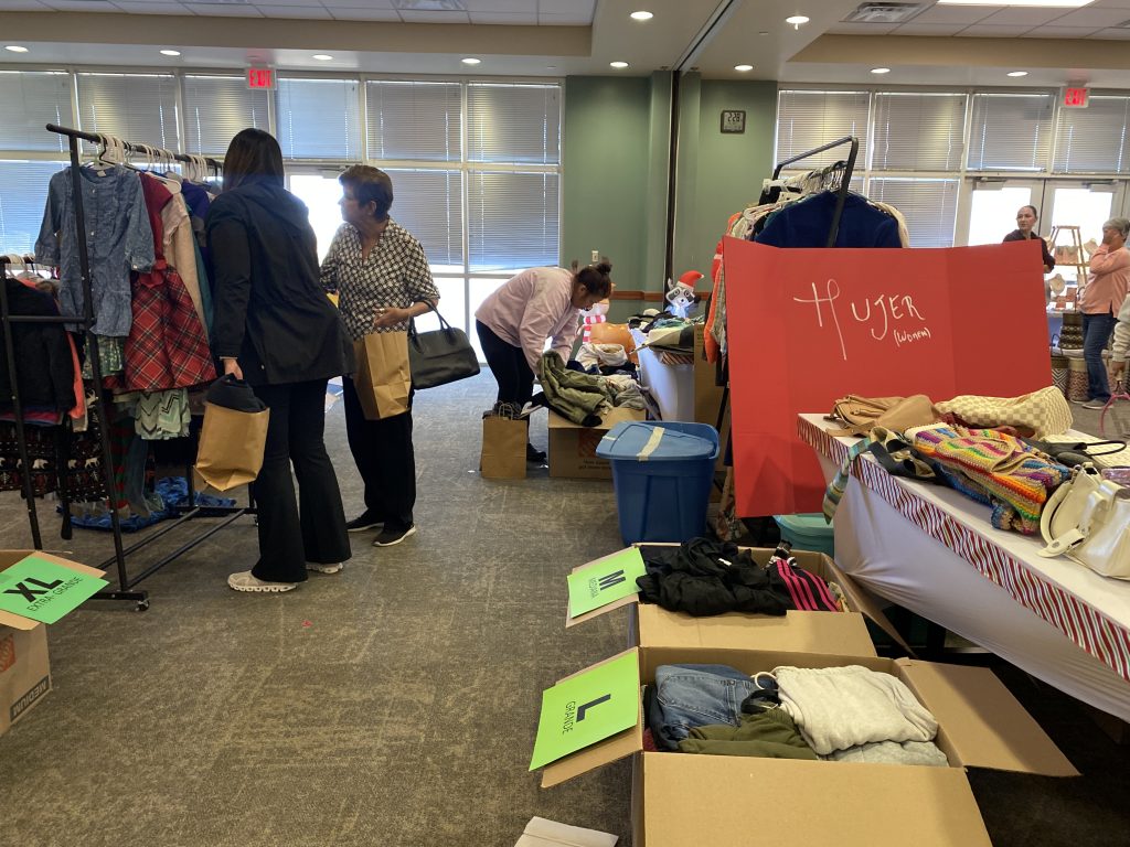 La gente compra en una venta navideña ropa de segunda mano para recaudar fondos para Aldea.