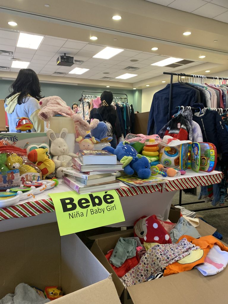 A table of secondhand baby items for sale at a Christmas fundraiser